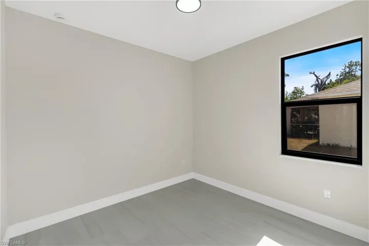 Spare room with baseboards and wood finished floors