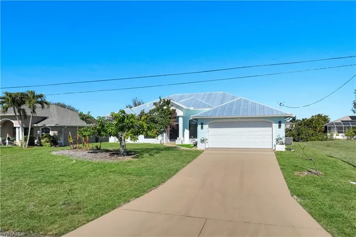 Single story home featuring driveway, a garage, and a front yard