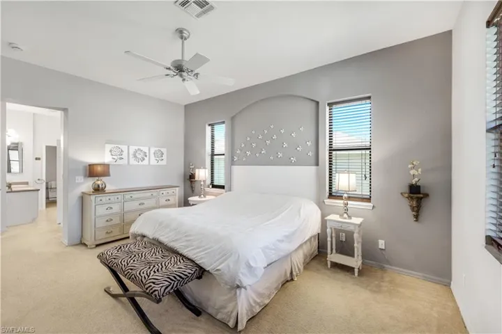 Primary Bedroom featuring light colored carpet and ceiling fan