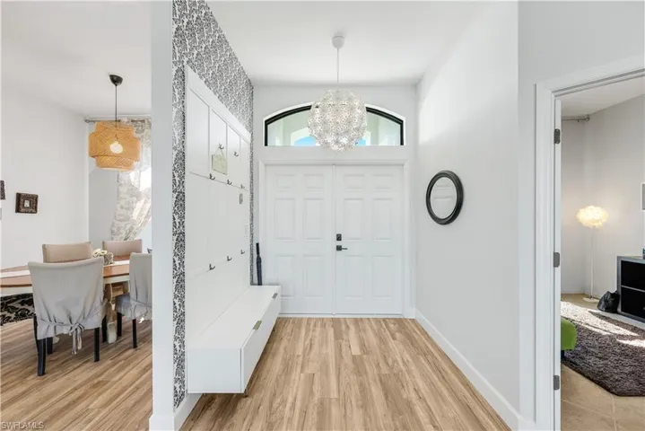 Foyer entrance featuring light wood finished floors and hanging lights