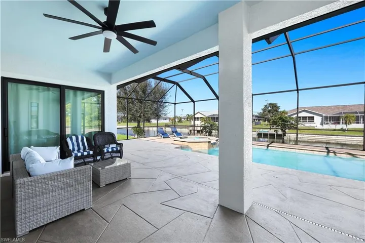 Combined pool / hot tub with a patio, glass enclosure, a sunroom, an outdoor lounge area, and a residential view