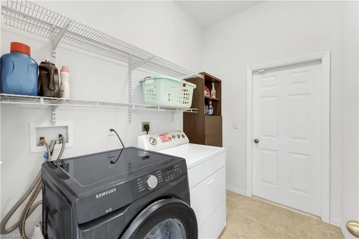 Laundry room with separate washer and dryer and baseboards