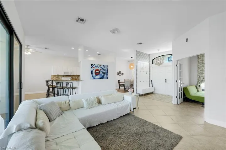 Living room with light tile patterned floors, recessed lighting, and a ceiling fan
