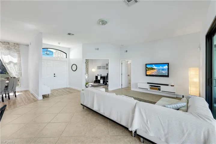 Living area with light tile patterned flooring and a chandelier