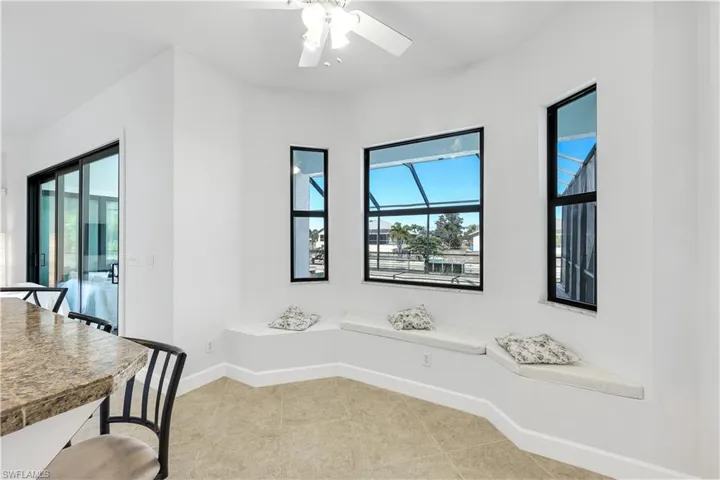 Dinette area with lots of natural light, a ceiling fan, and light tile patterned flooring