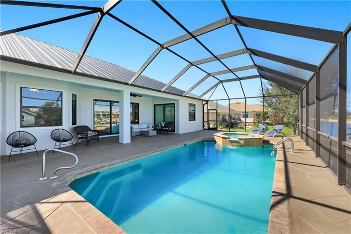 Relaxing pool / spa with a sunroom, a patio, a lanai, and outdoor furniture