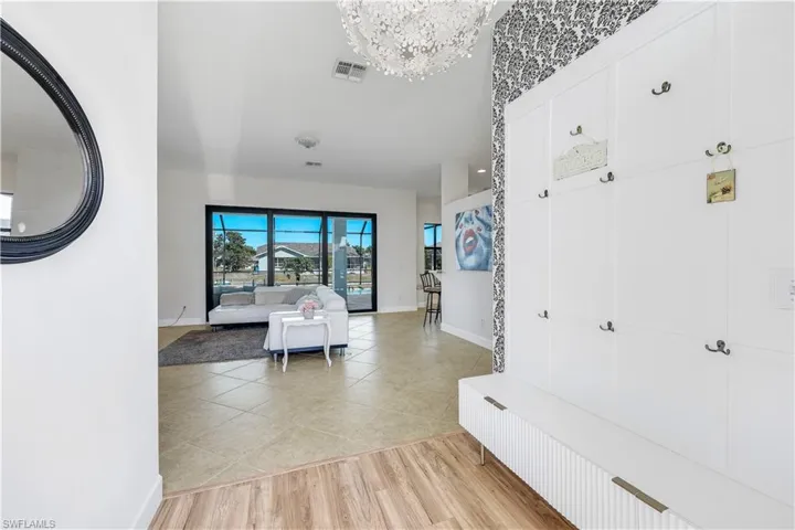 Hallway with light wood-style flooring and a chandelier