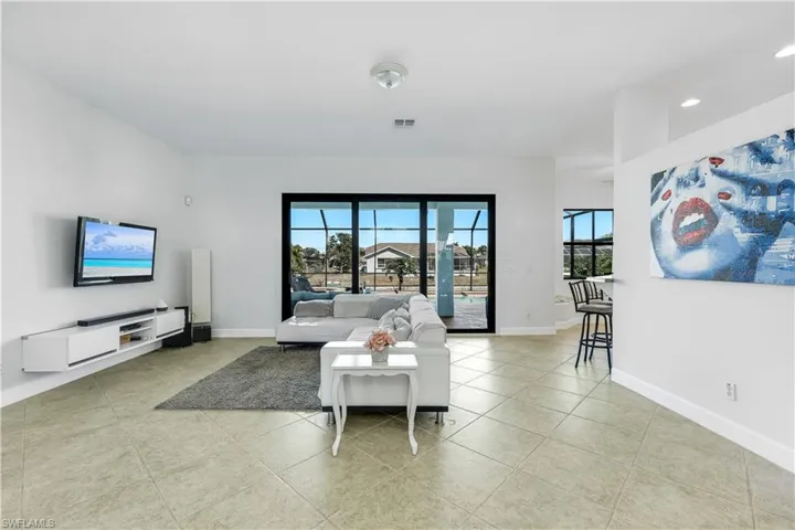 Living room with healthy amount of natural light and light tile patterned floors