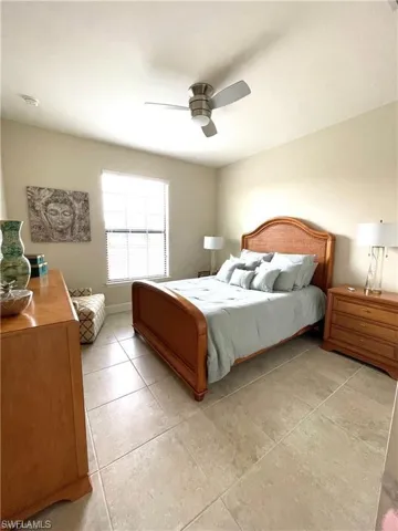 Bedroom with light tile patterned floors and a ceiling fan
