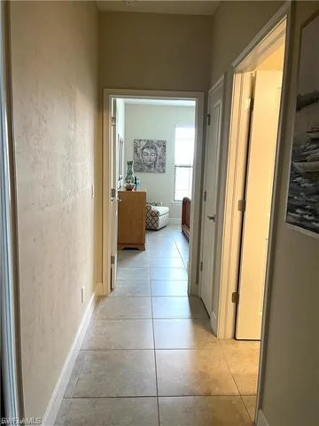 Corridor featuring baseboards and light tile patterned flooring