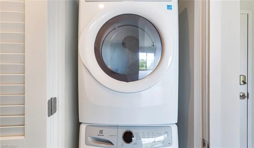 Washroom with stacked washer and clothes dryer