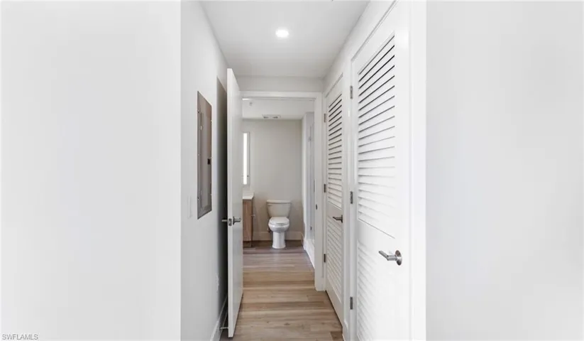 Corridor featuring light wood finished floors and electric panel