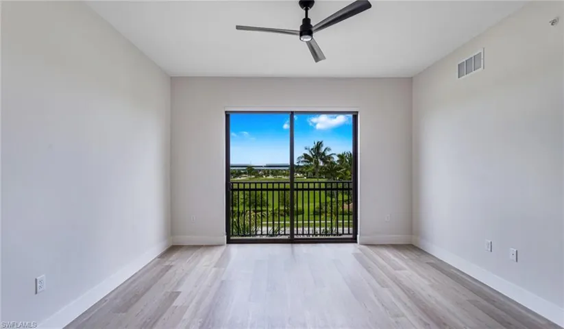 Empty room with light wood-style floors and a ceiling fan