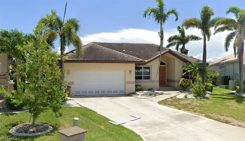 Ranch-style house featuring a garage and a front yard
