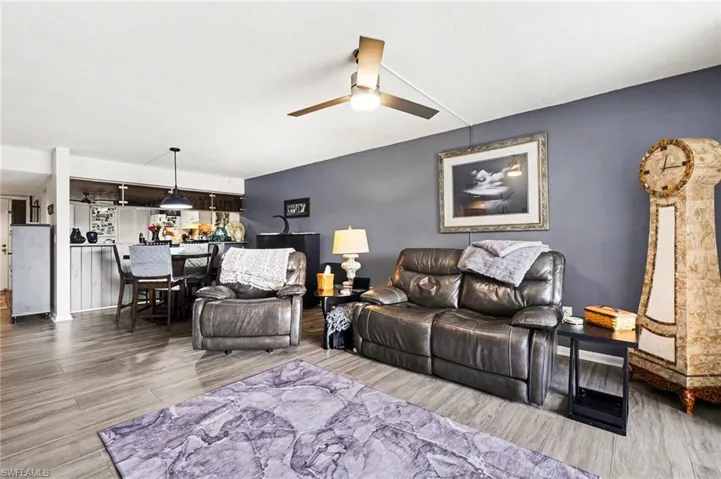 Living area with ceiling fan and light wood-style floors