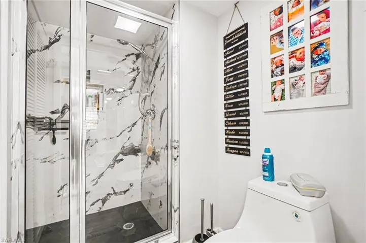 Bathroom with toilet and a marble finish shower
