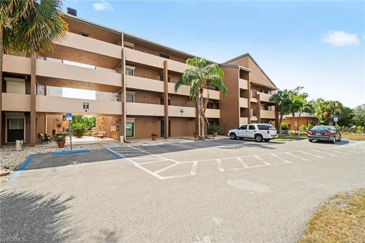 View of apartment building / complex featuring uncovered parking