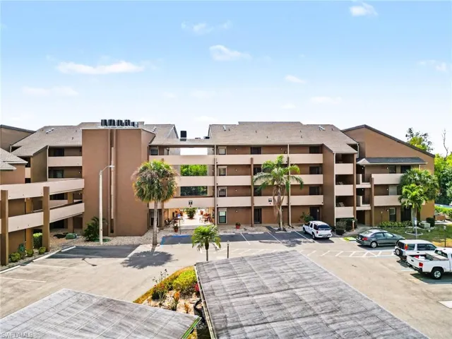 View of apartment building / complex featuring uncovered parking