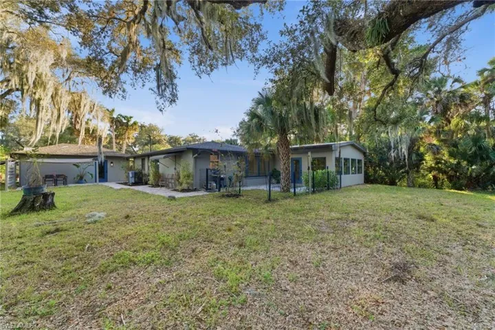 Rear view of property with a yard and stucco siding