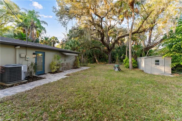 View of green lawn featuring a shed