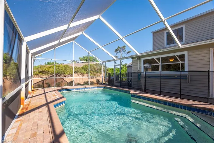 View of pool featuring glass enclosure and a patio area