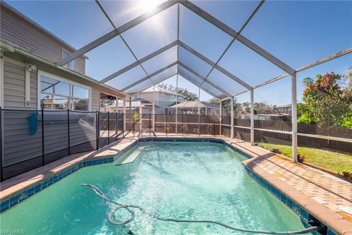 View of pool featuring glass enclosure and a patio area