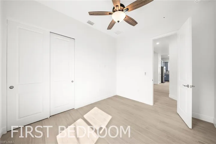 Unfurnished bedroom with light wood-type flooring, a closet, and ceiling fan