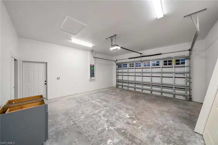 Garage featuring a garage door opener and electric panel
