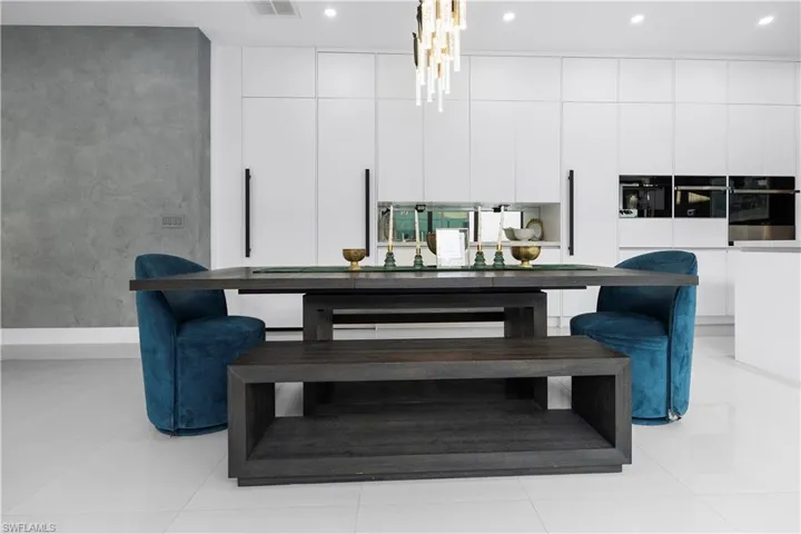 Dining room with light tile patterned flooring, recessed lighting, and a chandelier