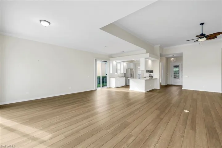 Open-concept living area with wood-finish flooring, recessed lighting, and a ceiling fan