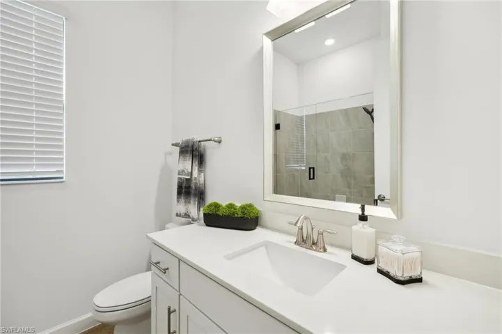 Bathroom featuring vanity, toilet, and a shower with shower door