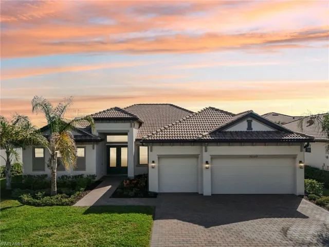 View of front facade featuring a garage and a lawn