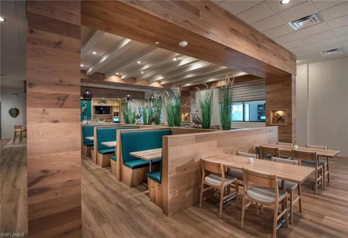 Bar featuring beamed ceiling, wood-type flooring, wooden walls, and a drop ceiling
