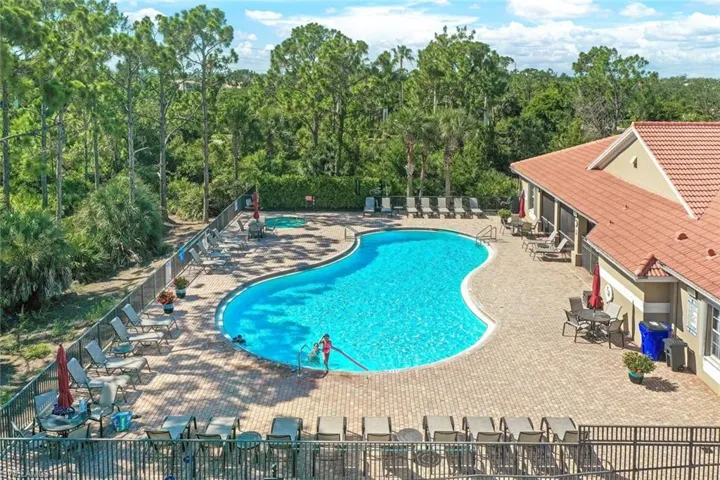 Community pool with a patio and a wooded view