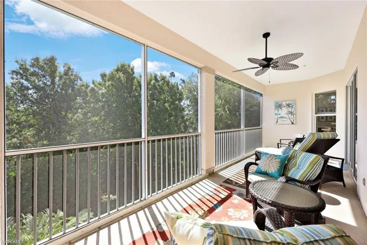 Sunroom with ceiling fan and a balcony