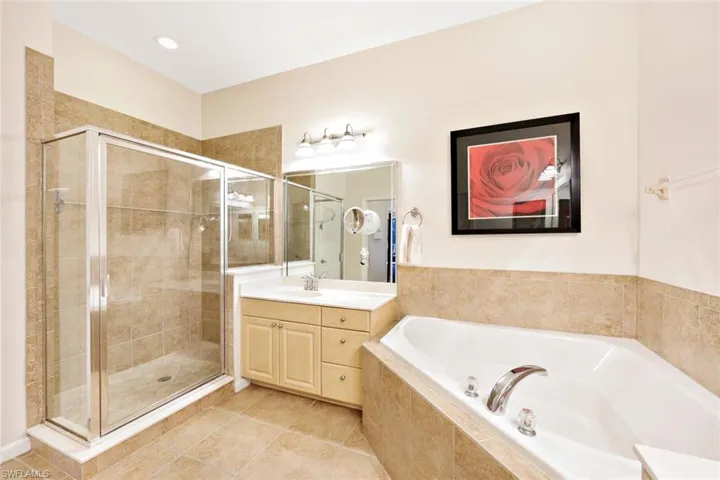 Bathroom with a shower stall, vanity, a bath, light tile patterned flooring, and recessed lighting