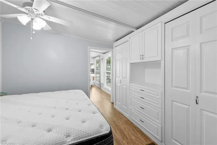 Bedroom with light hardwood / wood-style floors, ceiling fan, and vaulted ceiling