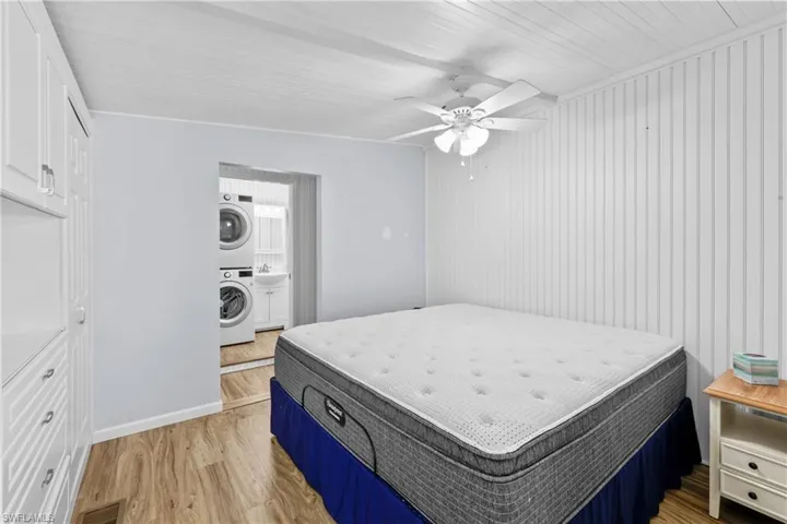 Bedroom with stacked washer / dryer, ceiling fan, and light wood-type flooring