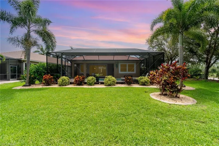 Back of property with a yard and a lanai