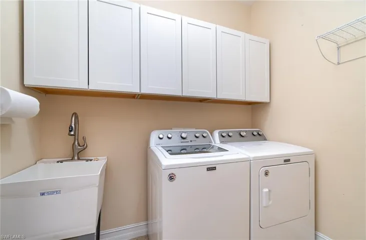 Washroom featuring cabinet space and washing machine and dryer