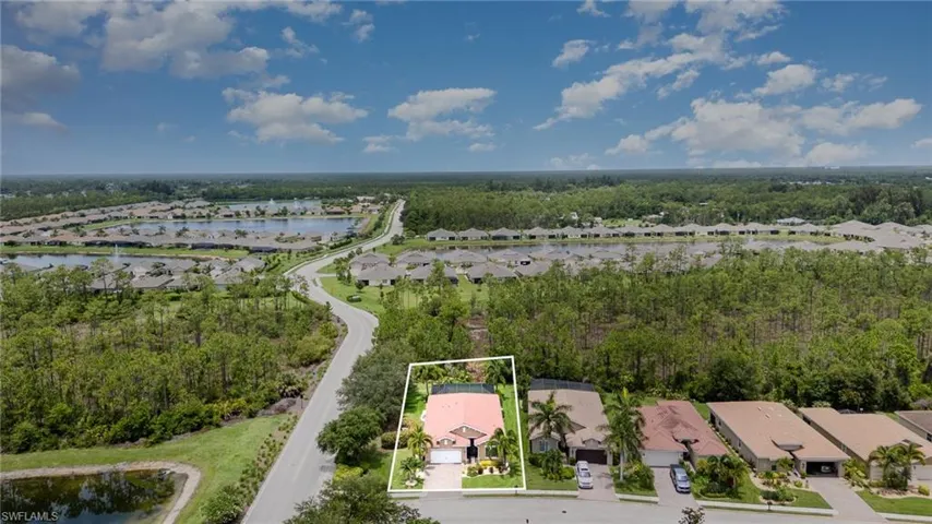 Aerial view of residential area featuring a large body of water and property parcel outlined