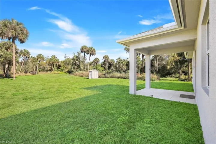 View of grassy yard featuring a patio