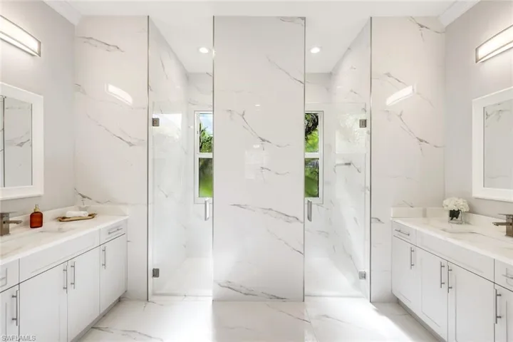 Full bath with vanity, light marble finish floors, recessed lighting, and a marble finish shower