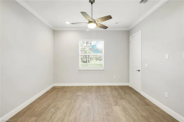 Spare room with light wood-type flooring, crown molding, ceiling fan, and recessed lighting