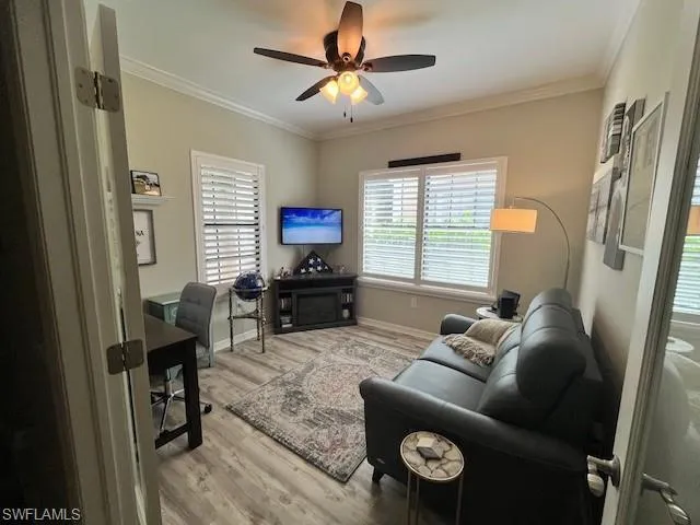 Living room featuring plenty of natural light, ceiling fan, wood finished floors, and ornamental molding