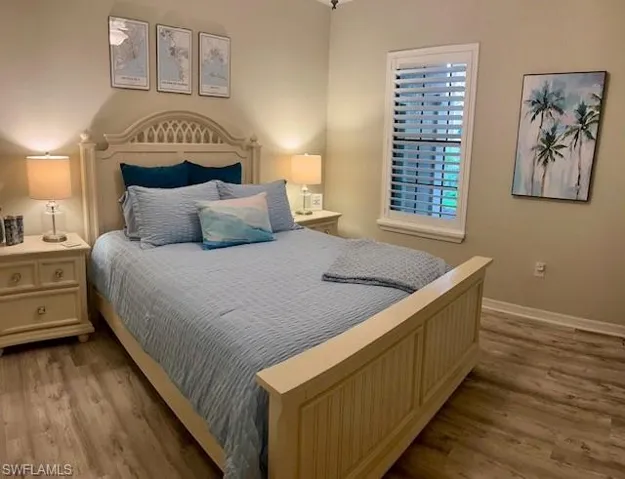 Bedroom with wood finished floors and baseboards