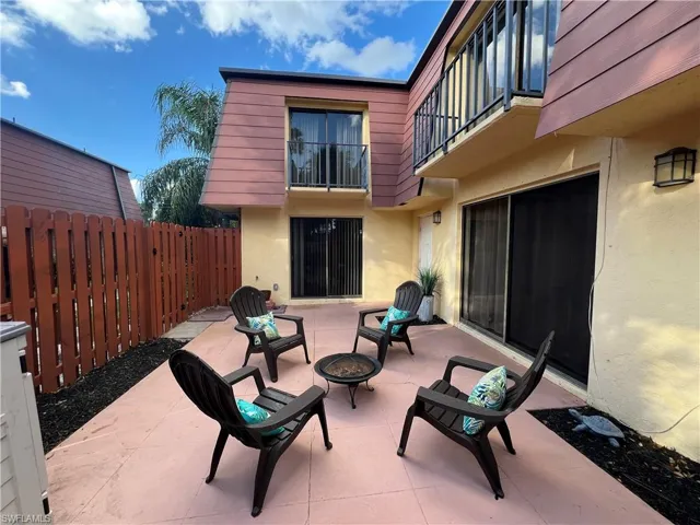 View of patio featuring two balconies and concrete patio with extra storage.