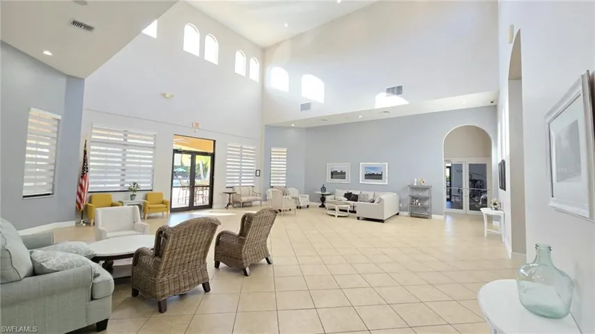 Living room featuring visible vents, arched walkways, and light tile patterned floors