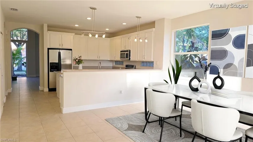 Kitchen with plenty of natural light, decorative light fixtures, a peninsula, and stainless steel appliances
