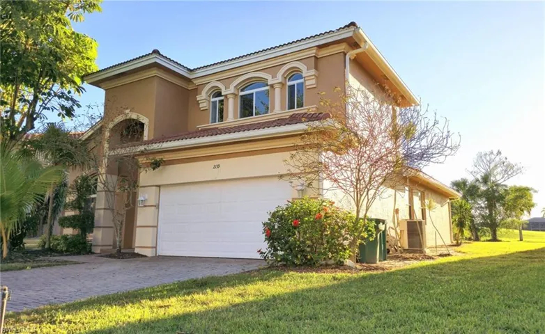 View of front of home featuring a tile roof, stucco siding, an attached garage, decorative driveway, and a front yard